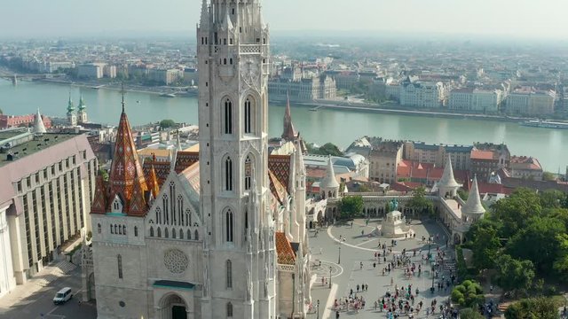 Budapest, Hungary - 4K drone flying slowly towards Matthias Church in front of Fisherman's Bastion at the heart of Buda's Castle District on a bright summer day with Parliament at background