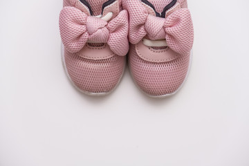 On a white background, pink baby sneakers, copy space
