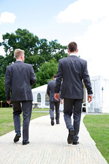close up of men in suits walking
