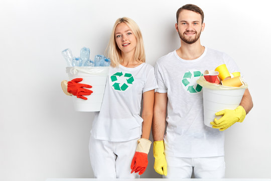 close up portrait of good looking tired volunteers holding garbage bags isolated on white background. man and woman have gathered litter, kindness.