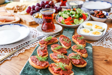 Huge healthy breakfast spread on a table with coffee, orange juice, fruit, muesli, smoked salmon, egg, croissants, meat and cheese.turkey