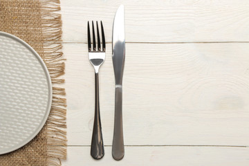 table setting. cutlery. Fork, knife and gray plate on a white wooden table. top view