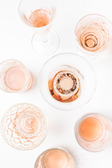 Sparkling rose wine in different glasses on white background