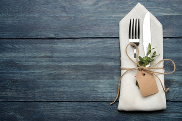 table setting. cutlery. Fork, knife in a white napkin on a blue wooden table. top view