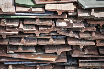 Old roof tiles taken from the roof and stacked in a pile