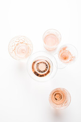 Sparkling rose wine in different glasses on white background