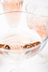 Sparkling rose wine in different glasses on white background