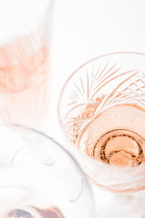 Fototapeta na wymiar Sparkling rose wine in different glasses on white background