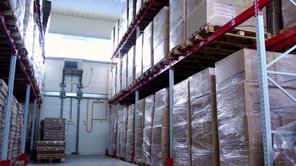Rows of shelves with boxes in modern warehouse