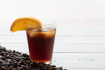 Ice Cold brew coffee with lemonade on white wooden.