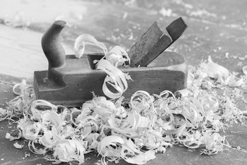 Old wooden hand plane for woodworking with wood shavings. Black and white.