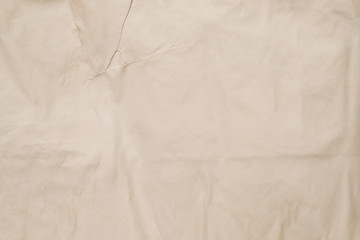 Beige colored wet paper. Creased texture. Moist surface effect. Abstract art background. Copy space.