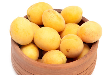 Ripe apricot in clay pot on a white background