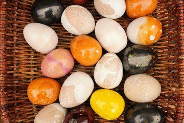 handmade multi colored easter eggs in a rustic straw basket