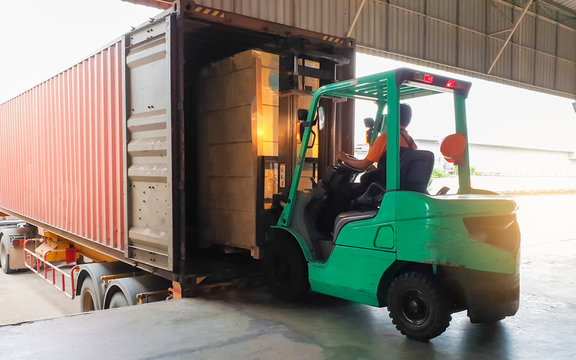  forklift tractor loading cargo pallet shipment with a truck container at dock warehouse. warehouse shipping logistics. freight truck transportation.
