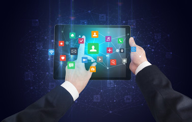 Hand using tablet with colorful bounce application symbols and icons concept