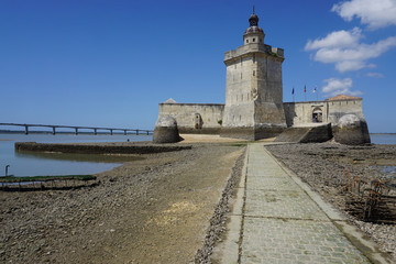 Fototapeta na wymiar old stone fortress accessible only at low tide on the west coast of France with the Oléron bridge