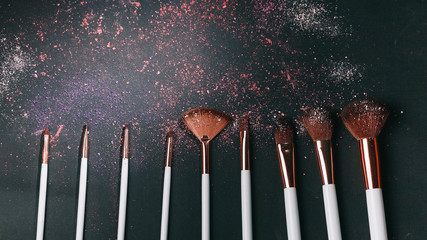 Set of professional makeup brushes on black background