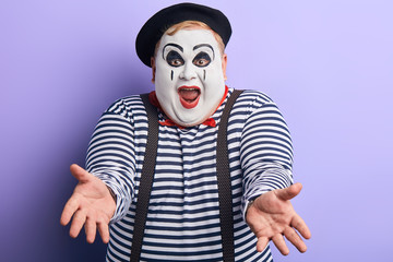 talented clown performing pantomime in the theater. close up portrait, isolated blue background, studio shot,positive emotion and feeling. comedy