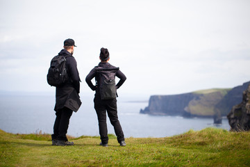Hombre y mujer observando los acantilados de Moher en Irlanda
