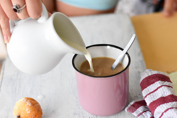 Woman pouring milk into coffee cup/latte/ Breakfast table-Starting a day