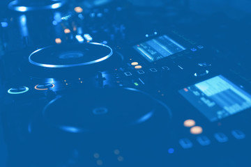 Professional dj turntables setup on stage in blue lights.Hip hop disc jockey turn table system on...