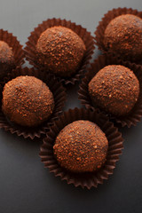 chocolate petit fours over black background. Top view.
