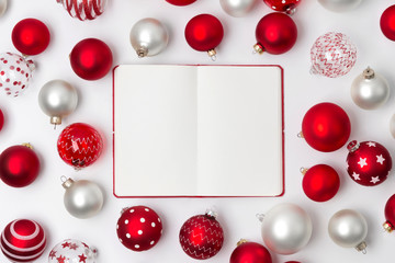 Red and white matte Christmas baubles decoration and notepad on white background with copy space