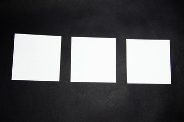 White square stickers of paper of the same size on a black background