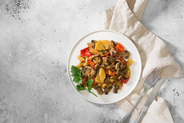 Stewed vegetables in a white plate on a gray table. Healthy diet. Vegetarian food