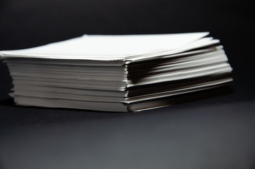 stack of white paper small squares stickers on black background