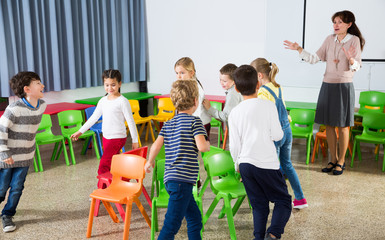 Kids and teacher playing musical chairs