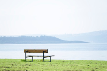 Lonely empty bench in open tranquil space on Scottish west coast town in Argyll and Bute