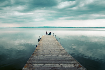 Conversation between two friends sitting on the jetty