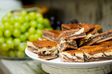 a plate with pieces of cake and in the background a plate with grapes
