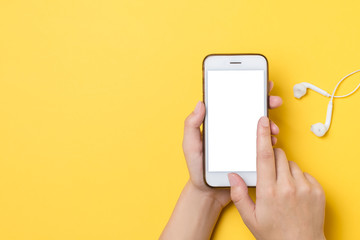 Modern smartphone with a blank screen in the hands of a girl, on a yellow background