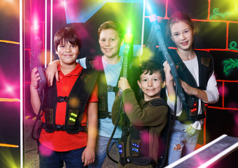 Group portrait of happy teenagers with laser guns having fun on