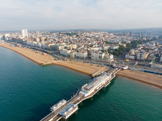 Naklejka na ściany i meble Aerial photo of the famous Brighton Pier and ocean located in the south coast of England UK that is part of the City of Brighton and Hove, taken on a bright sunny day showing the fairground rides.