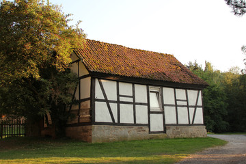 old medieval european half-timbered fach verk house among green trees