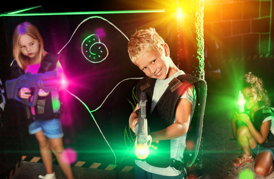 Preteen boy with laser pistol playing on labyrinth