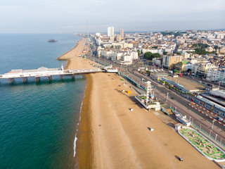 Fototapeta premium Aerial photo of the famous Brighton Pier and ocean located in the south coast of England UK that is part of the City of Brighton and Hove, taken on a bright sunny day showing the fairground rides.