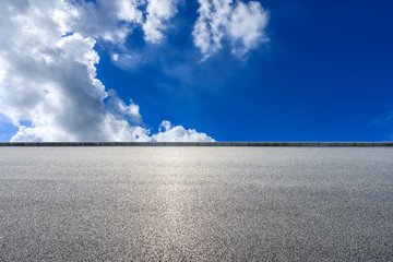 Asphalt highway road and blue sky with white clouds