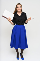 Full-length Vertical Portrait of a cute brunette middle-aged manager woman with beautiful curly hair in a business suit and blue skirt on a white background with a folder in her hands.