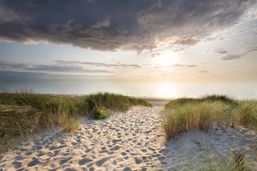 chemin de sable vers la plage de la mer du nord au coucher du soleil