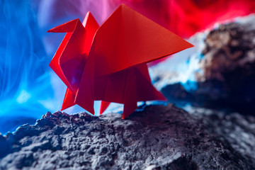 The dragon in the volcano. The conceptual image is an inner force. The dragon on the stone. Metaphor weakness outside-force within. A metaphor for a man of strong spirit. Origami paper.