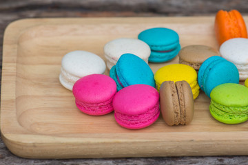 Colorful Macaroons in dish on wooden table