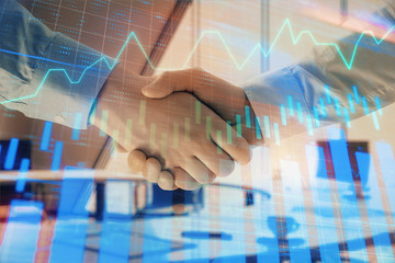 Obraz na płótnie Canvas Multi exposure of financial graph on office background with two businessmen handshake. Concept of success in business