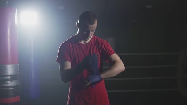 Man boxer wapping hands getting ready for fight. Kickboxer prepare for training.