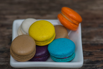 Colorful Macaroons in dish on wooden table