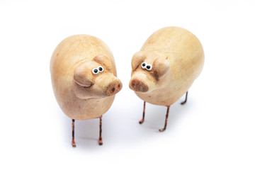 Small clay figurines of pigs isolated on a white background. A symbol of prosperity and prosperity.